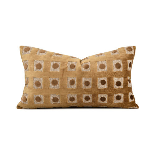 A rectangular throw pillow in a warm mustard-gold velvet fabric, featuring a woven geometric pattern of cream and brown squares with circular motifs, set against a plain white background.